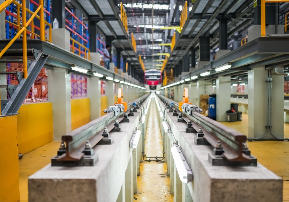 Portrait of engineer and apprentice in workshop of railway engineering facility